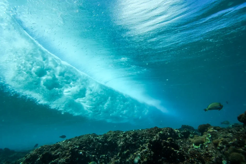 Underwater perspective of a powerful breaking ocean wave above a coral reef in Bali